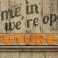 come in we'are open - future. Foto einer Tür mit diesem Spruch darauf.